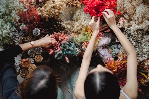 Women choosing dried flowers for arrangement