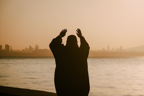 Silhouette of a Person with Hands Up