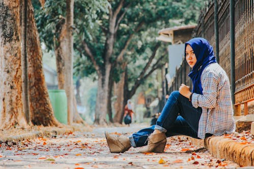 Free Woman in Blue Hijab Sitting on Ground Stock Photo