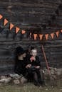 Woman in Black Long Sleeve Shirt Sitting Beside Boy in Black Jacket