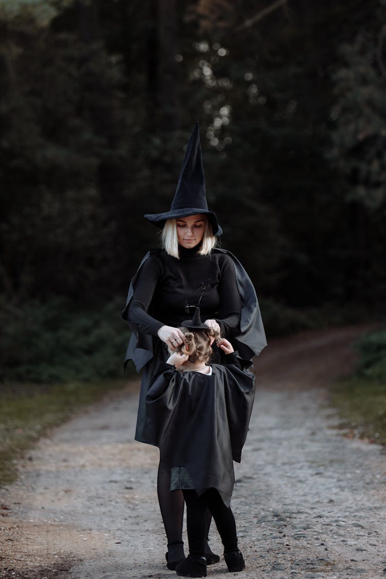 Mother And Daughter Wearing Halloween Witch Costumes