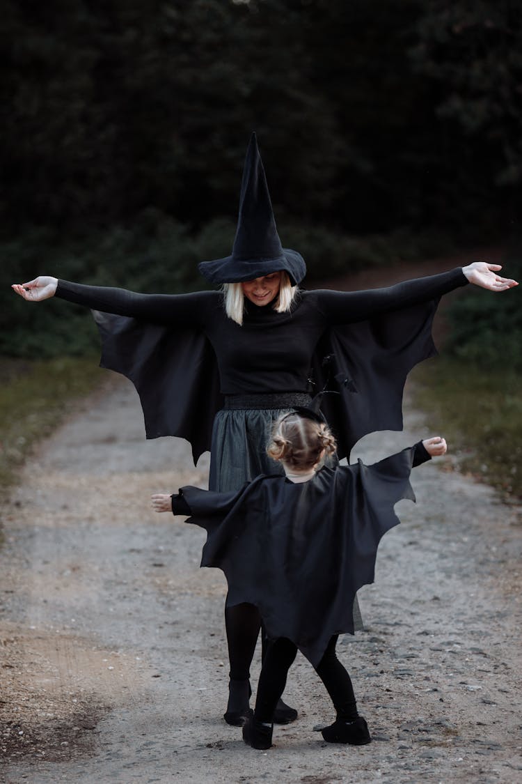 A Woman And Her Daughter Wearing Matching Halloween Costumes