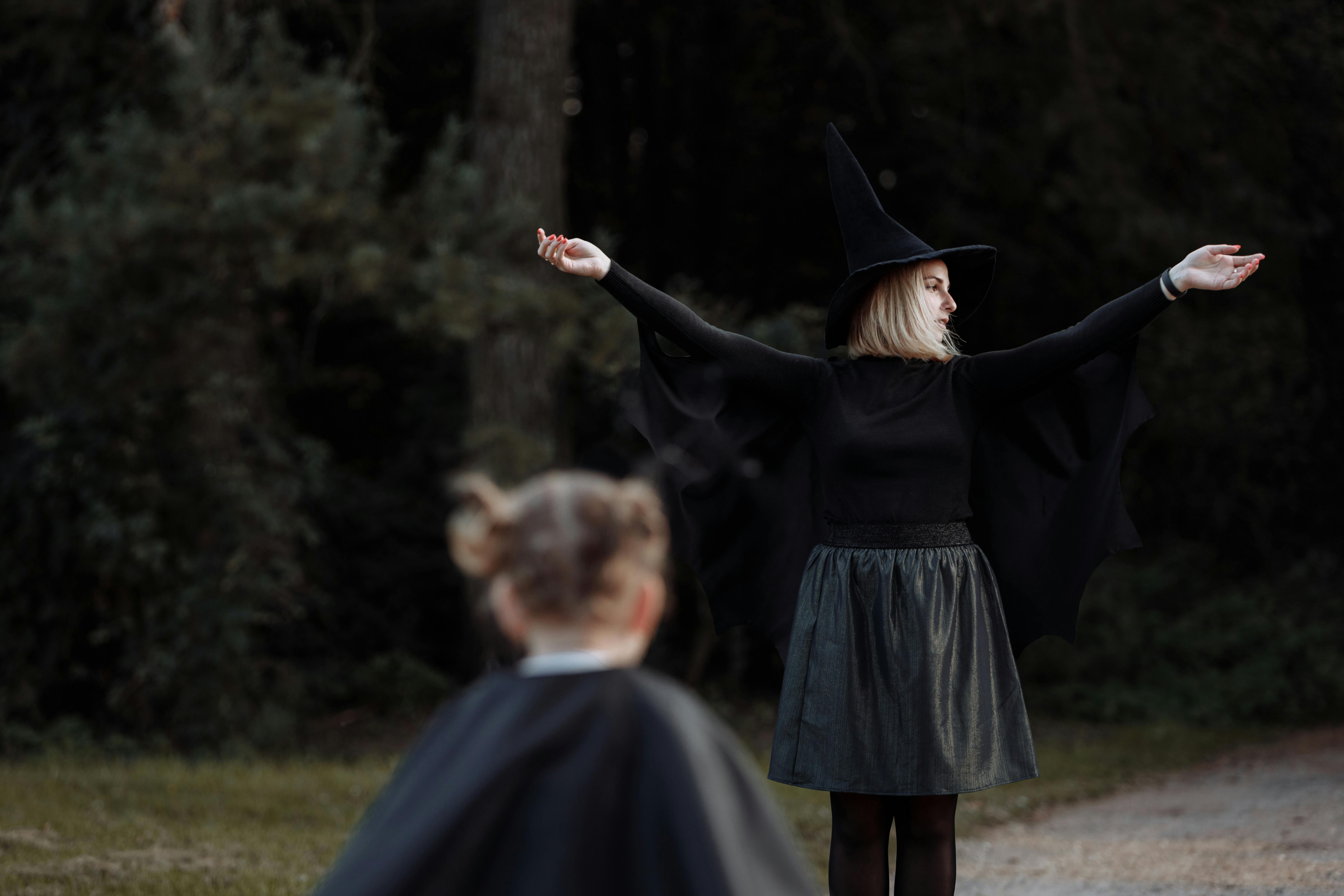 woman in black long sleeve dress holding girl in black dress