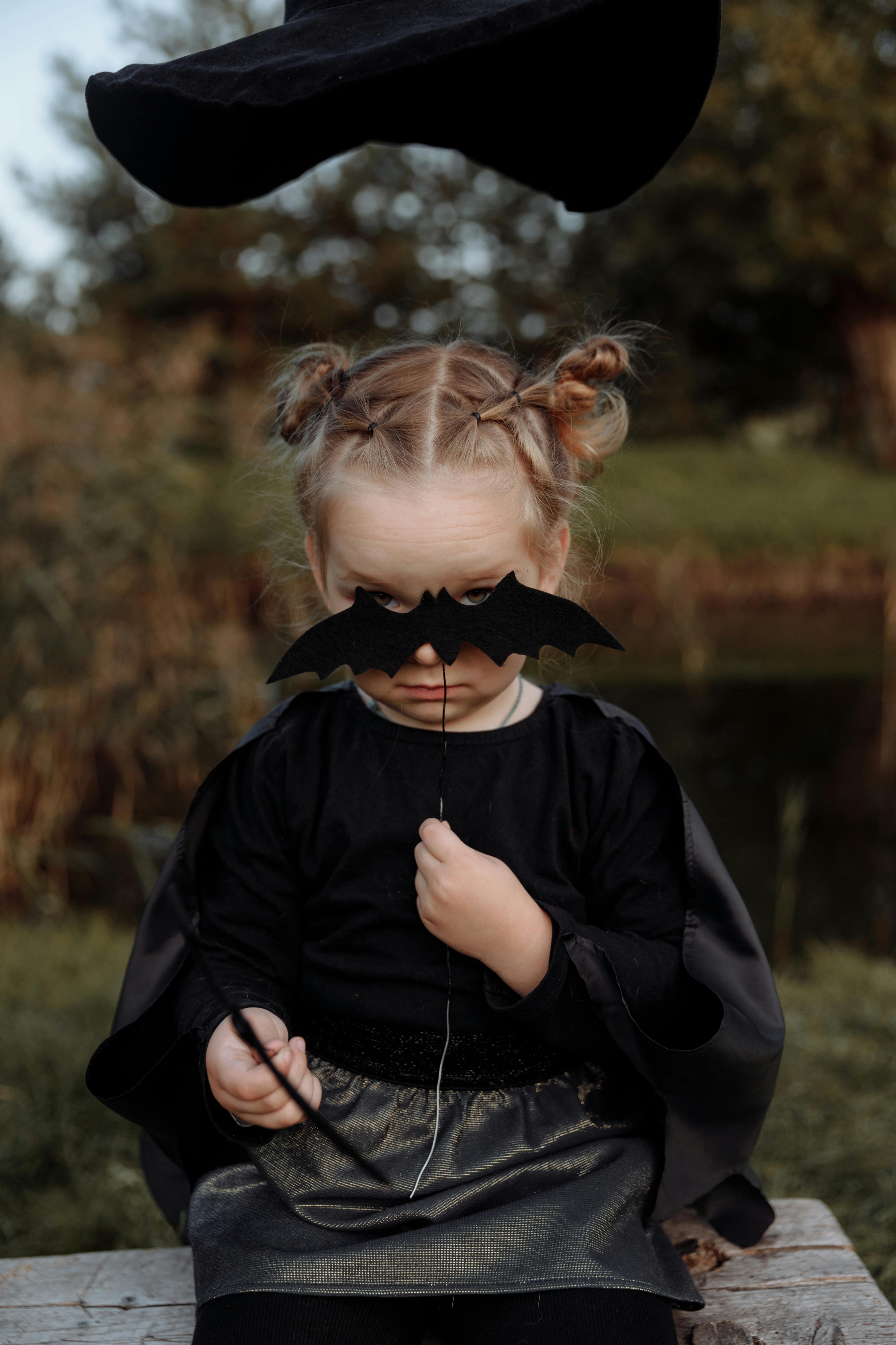 girl in black jacket standing near lake