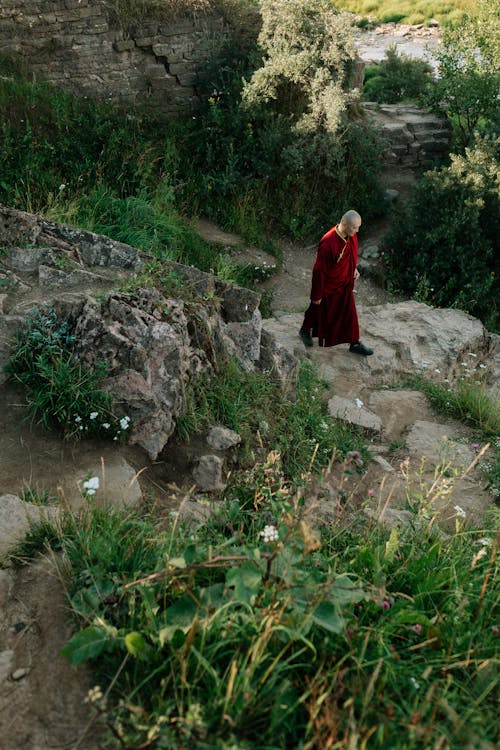 바위 바닥에 서있는 빨간 드레스 여자