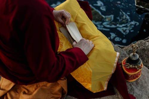 Buddhist Monk Looking Through Yellowed Papers