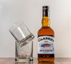Black and White Labeled Bottle Beside Clear Drinking Glass