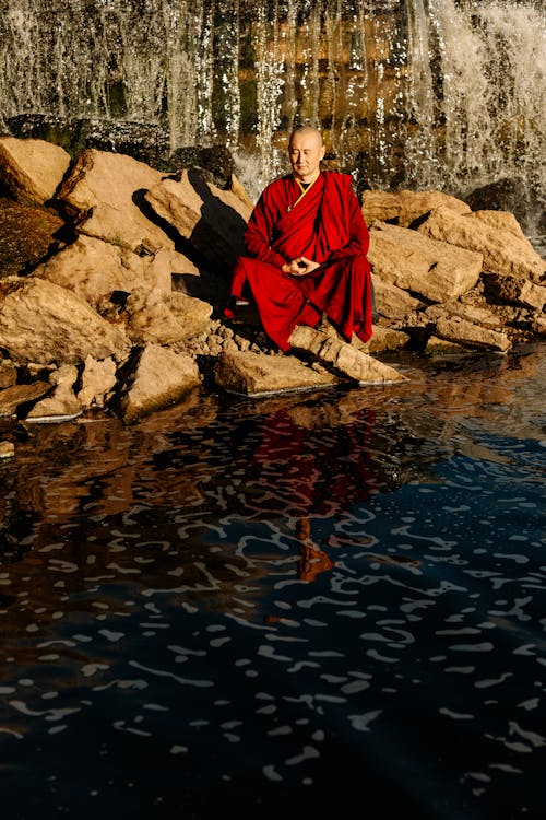 물 몸 근처 바위에 앉아 빨간 드레스 여자