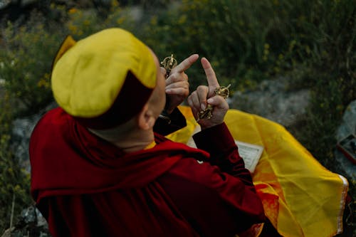 Tibetan monk praying while holding the Ghanta bell and Dorge