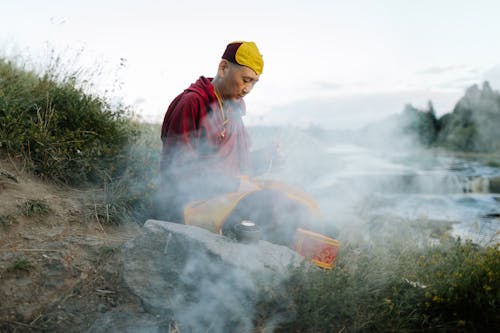 Tibetan Monk Praying on the Riverbank Amidst the Smoke