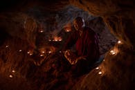 Man in Red Jacket Sitting on Rock