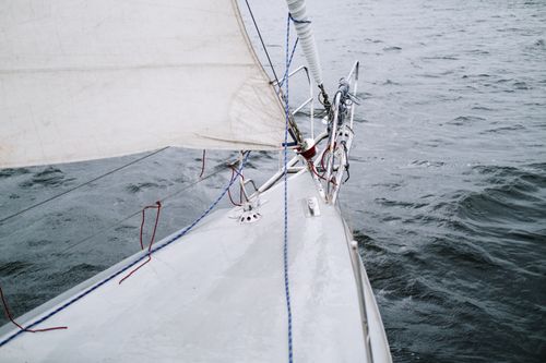 Free View from a yacht's bow sailing on the open sea, showcasing ropes and sails in a nautical setting. Stock Photo
