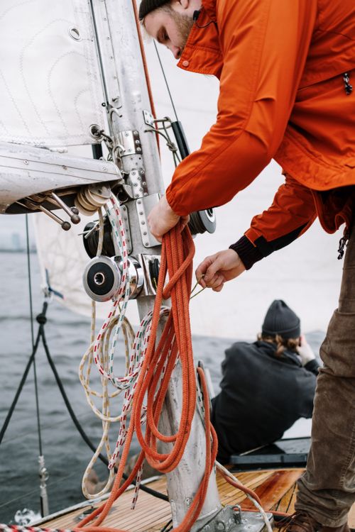 Man Ropes Ship Man in a Jacket Fixing the Ropes on the Ship · Free Stock Photo