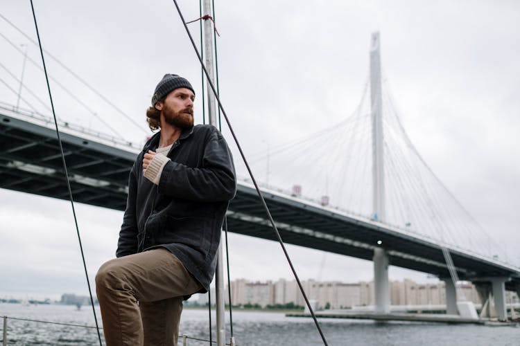 Man On A Boat Below The Bridge