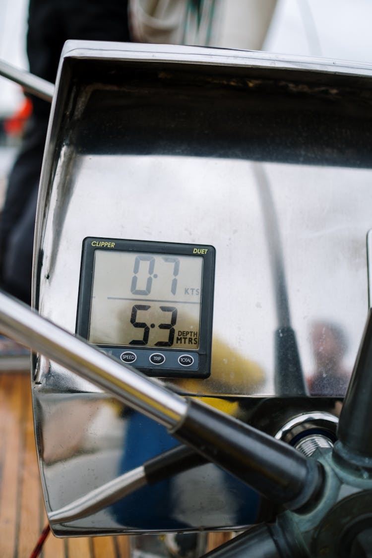 A Digital Marine Equipment Near  A Boat's Wheel