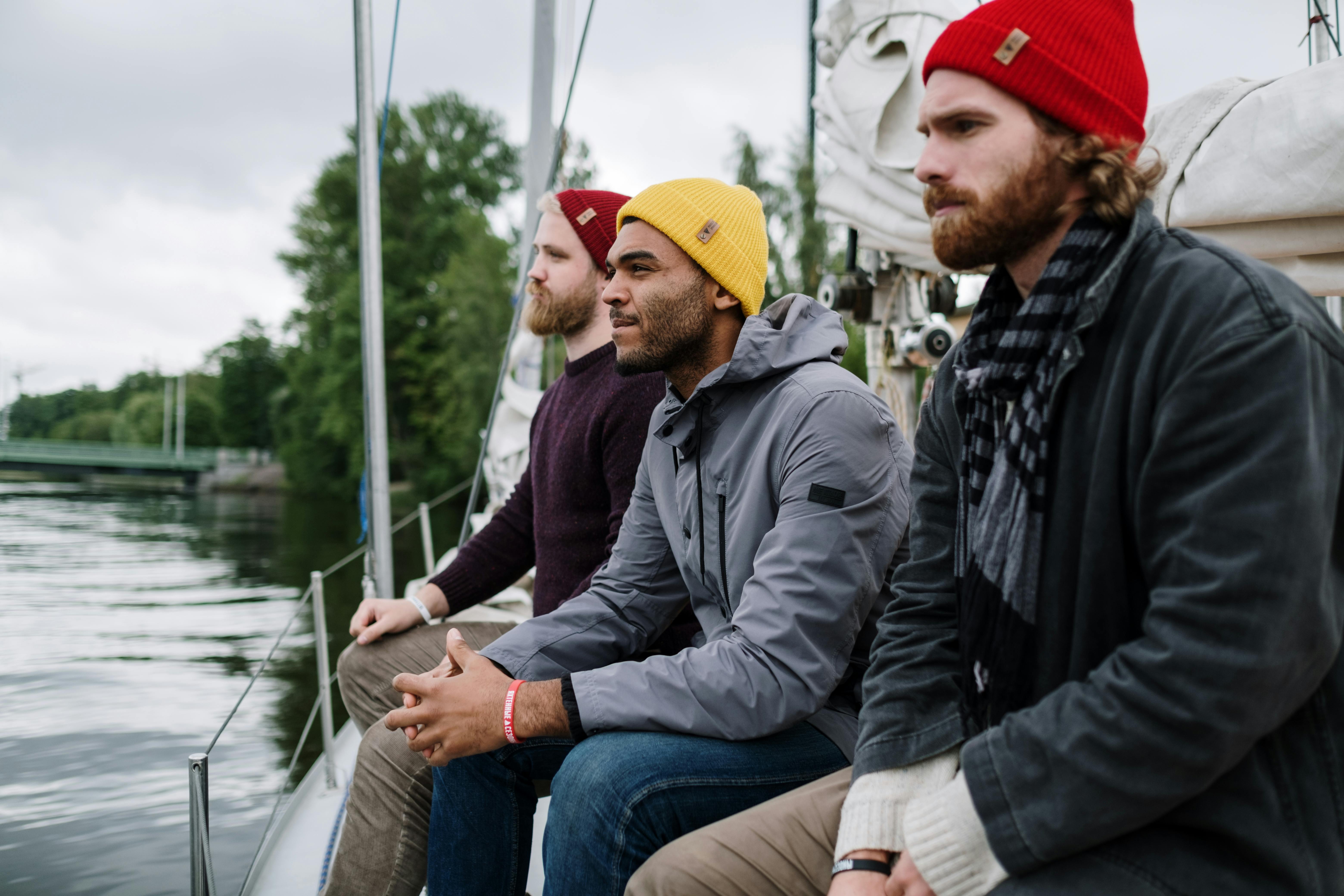 man in black jacket and yellow knit cap sitting beside man in black jacket