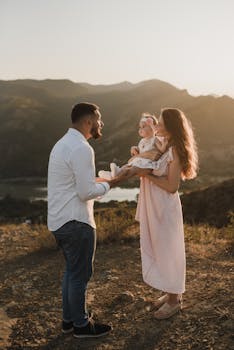 日落时分，风景如画，一对夫妇在户外深情地抱着他们的孩子