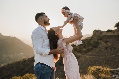 Free A joyful family bonding outdoors during a beautiful sunset, capturing love and togetherness. Stock Photo