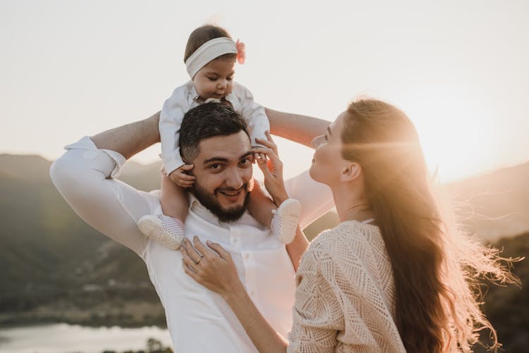 A Man Carrying His Daughter On His Shoulders