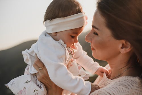 白色长袖衬衫的女人抱着婴儿的白色长袖衬衫