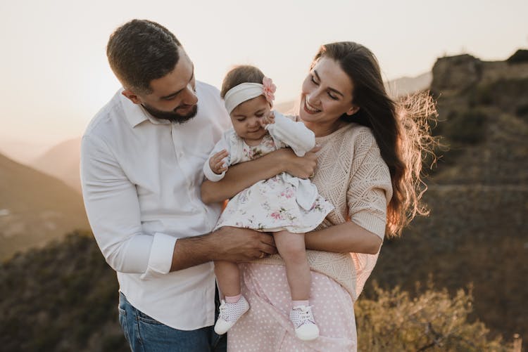 A Father And Mother Looking The Baby Girl