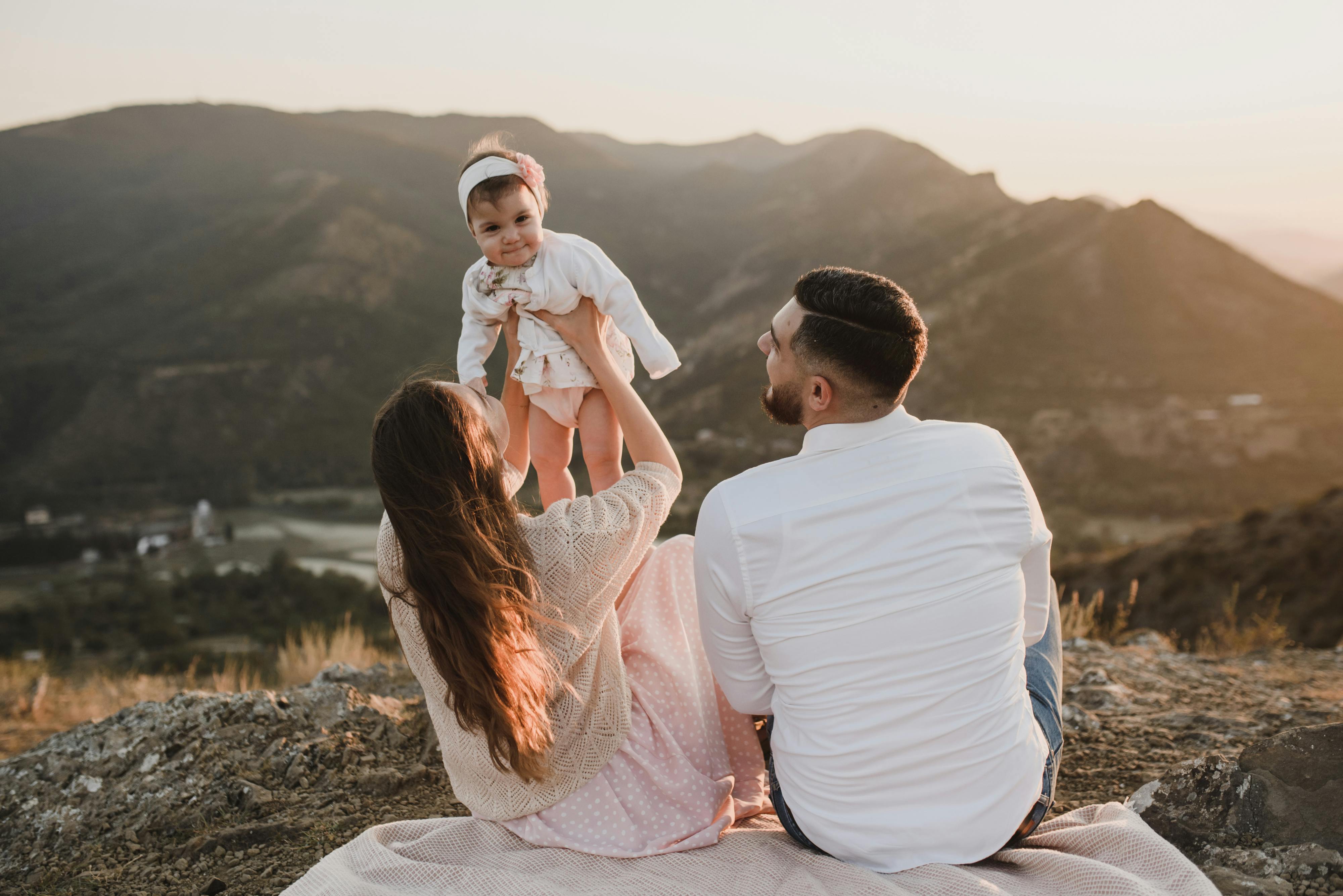 A mom and dad playing with their little daughter