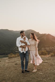 A young family with a baby enjoys a peaceful mountain walk at sunset, capturing moments of togetherness and warmth.