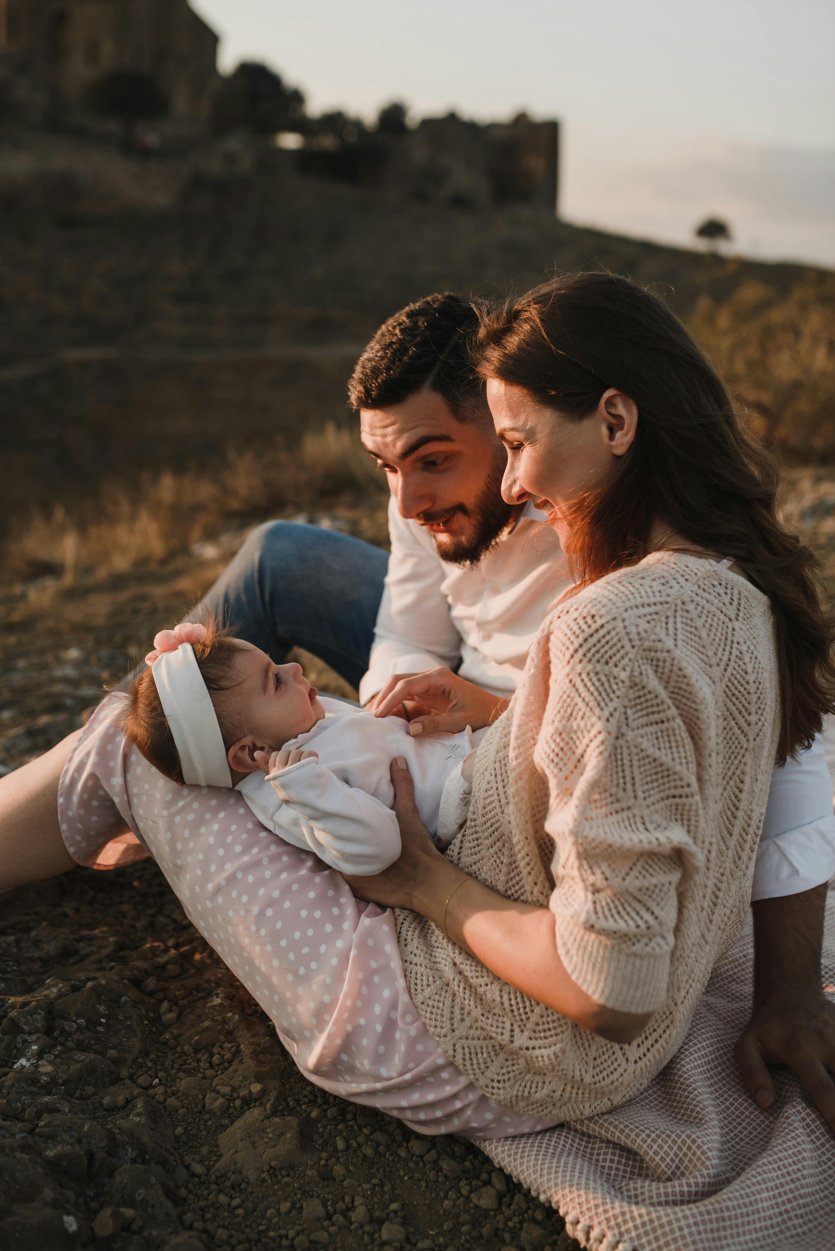 a father and mother looking the baby girl