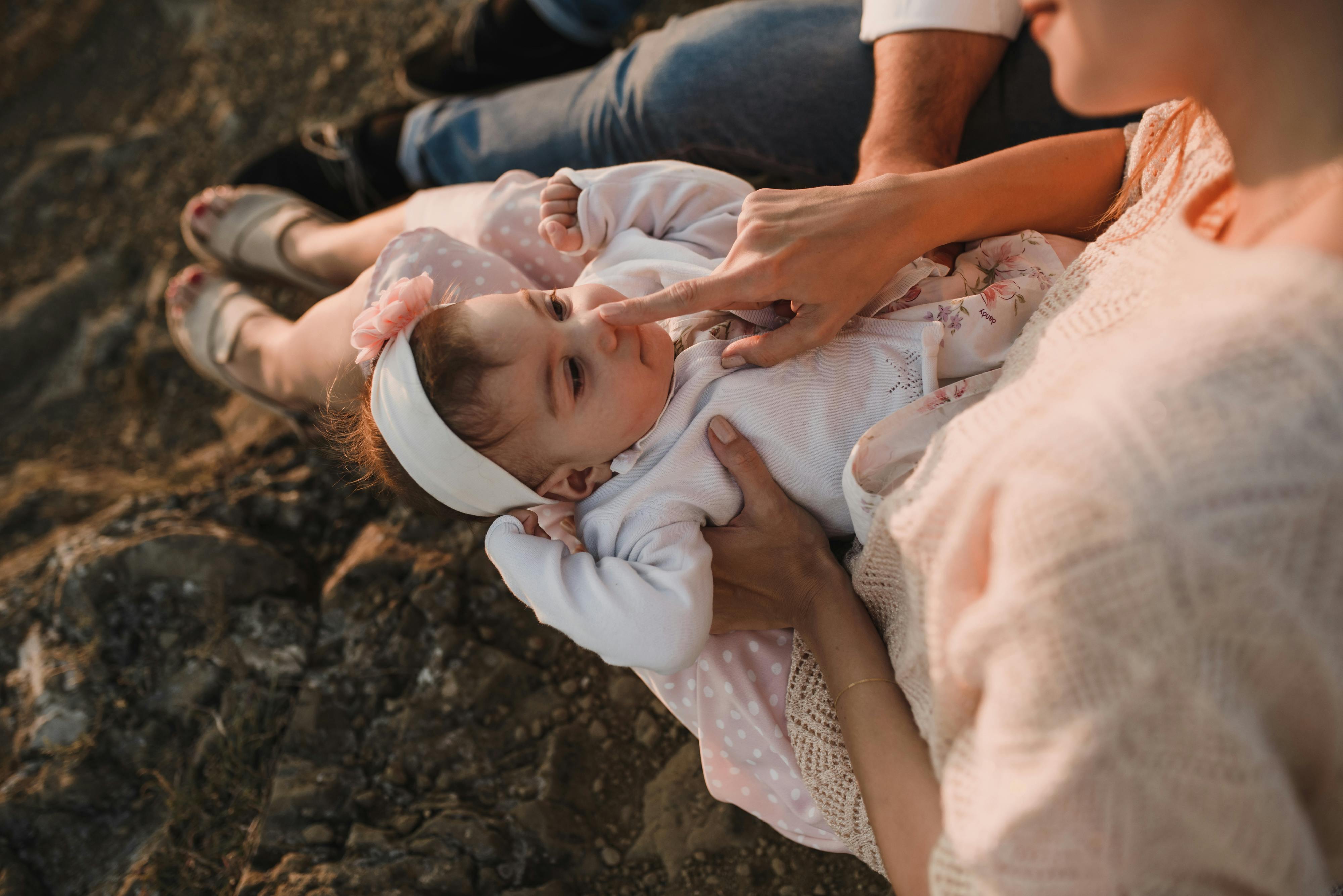 mother sitting and touching baby daughter nose