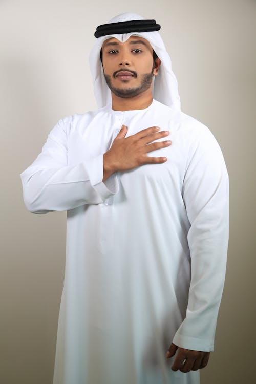 Man in Traditional Clothing Standing with Hand on Heart