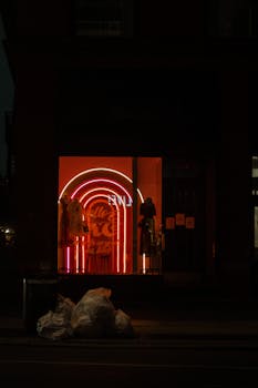 Dimly lit city storefront with vibrant neon lights and street ambiance at night.