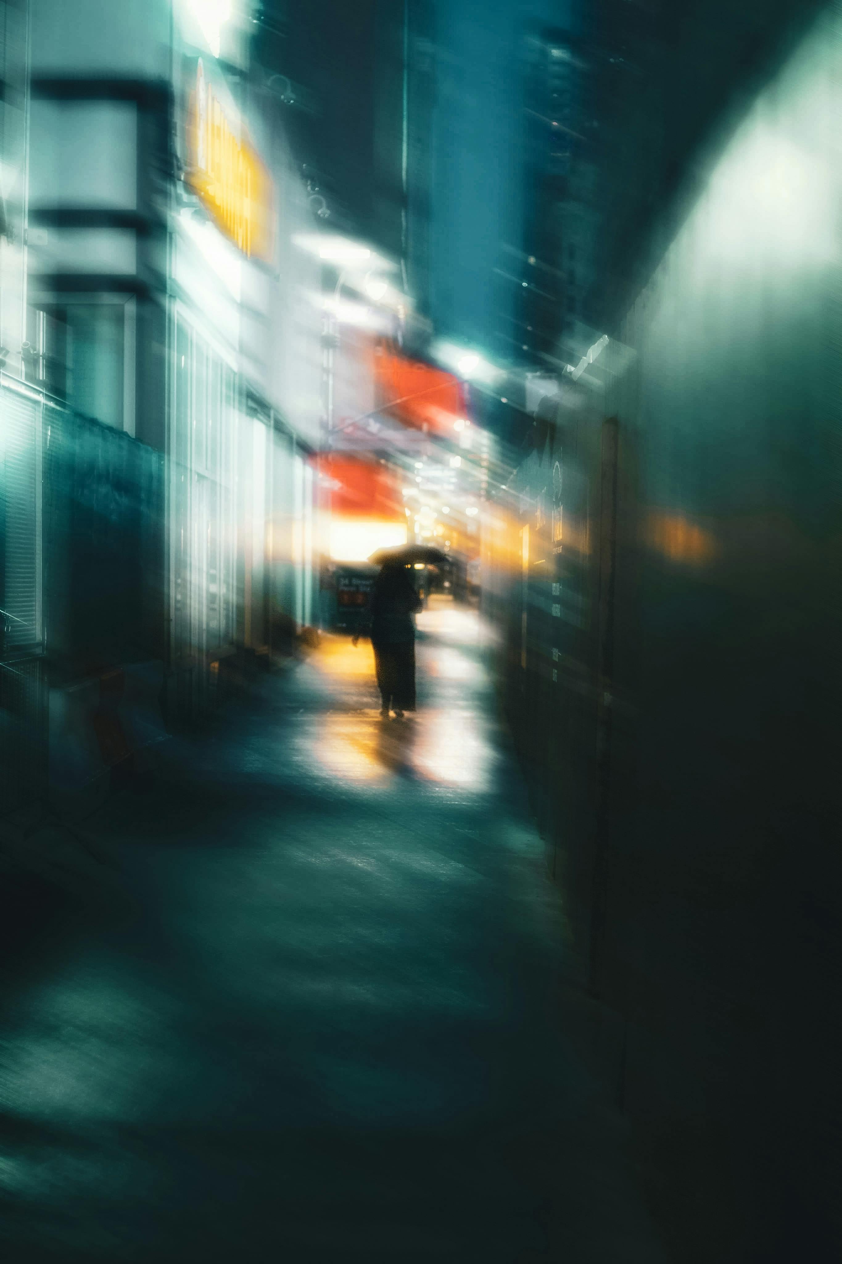 silhouette of unrecognizable woman walking on night street with umbrella