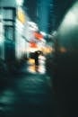 Silhouette of unrecognizable woman walking on night street with umbrella