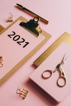 Stylish arrangement of pink office supplies featuring a 2021 calendar, perfect for modern workspaces.