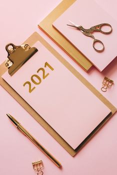 粉色背景上印有2021年字样的剪贴板，采用扁平化设计，是一款粉色办公用品