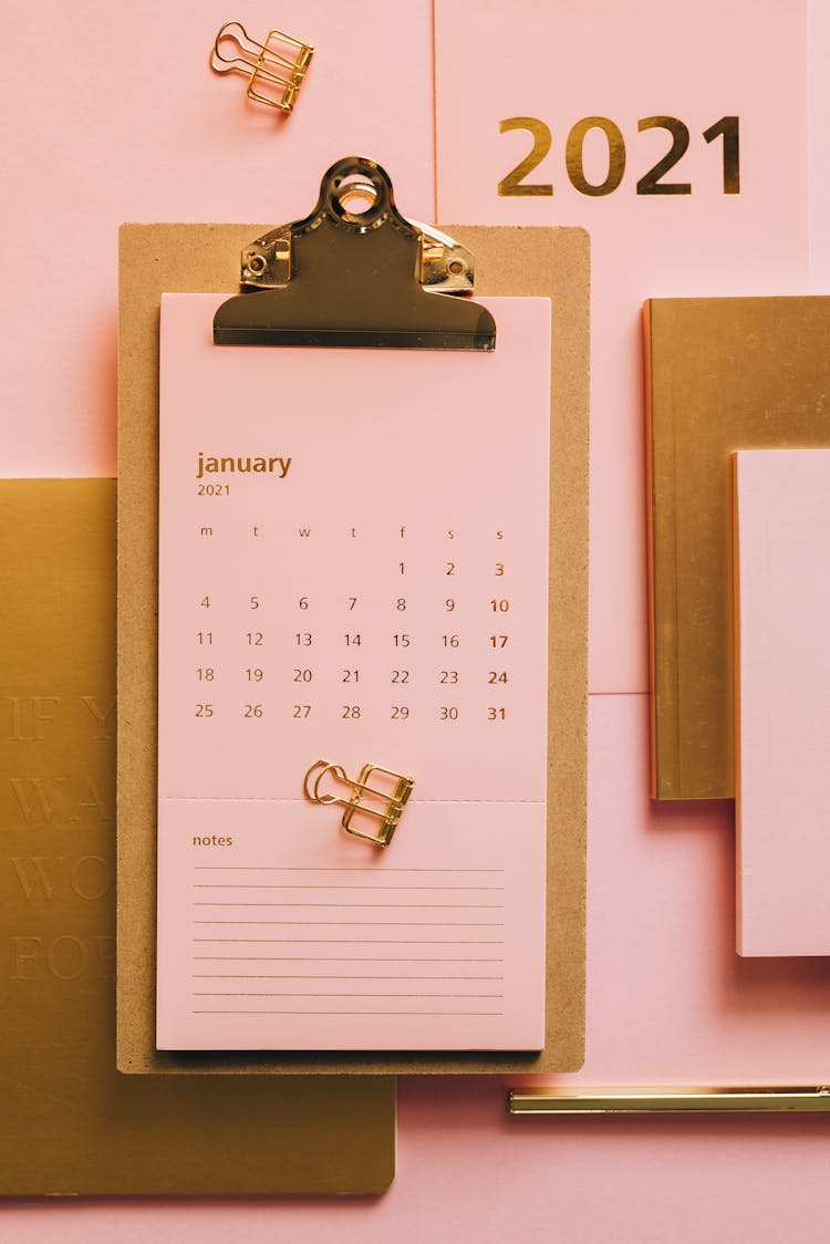 Clipboard With Pink Calendar On Table