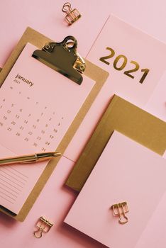 粉色背景上印有2021年日历和办公文具图案，并点缀着金色