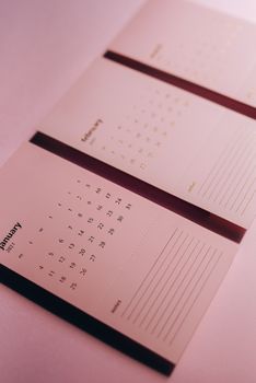 这是一款时尚的粉色极简主义日历，背景虚化，展示了一月、二月和三月