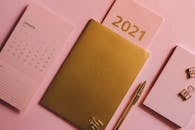 这款极简主义桌面配有2021年日历、金色笔记本和粉色背景固定装置