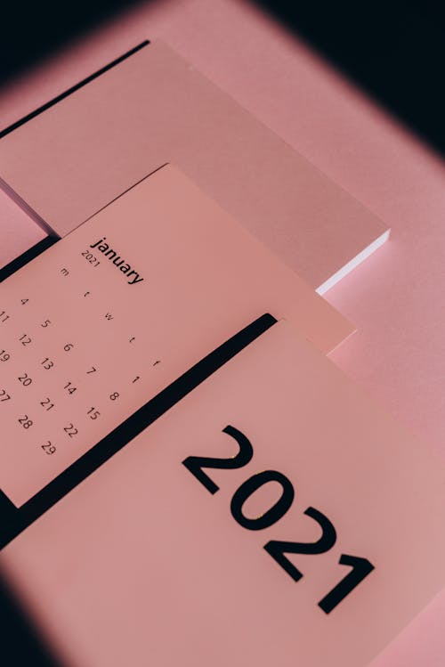 From above of 2021 year calendar with weekly dates in rows in monochrome pink light