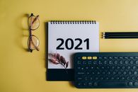 这款2021年日历以黄色为背景，印有眼镜和键盘图案，非常适合组织主题