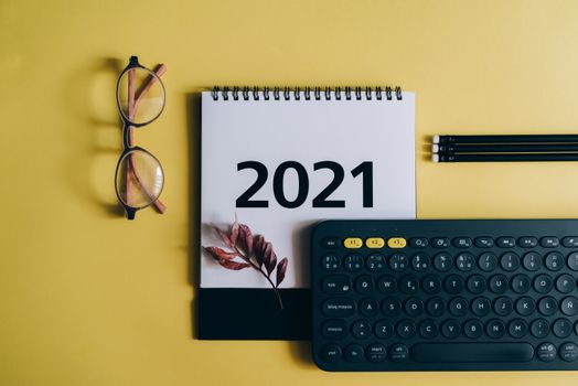 这款2021年日历以黄色为背景，印有眼镜和键盘图案，非常适合组织主题