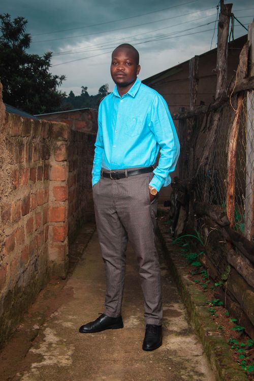 Free Young adult man posing outdoors, showcasing casual style against a brick wall, embracing confident elegance. Stock Photo