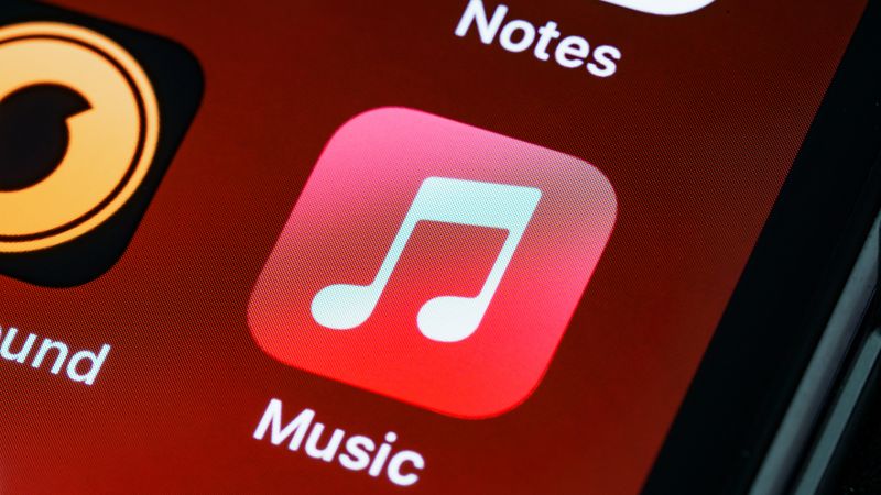 Detailed close-up of an iPhone home screen featuring the music app icon.