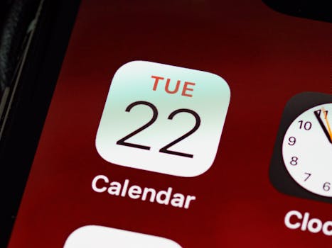 Detailed close-up of an iPhone home screen focused on the calendar app icon.