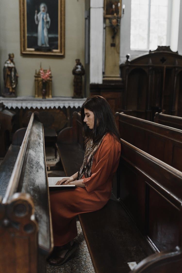 A Woman Reading A Bible In The Church