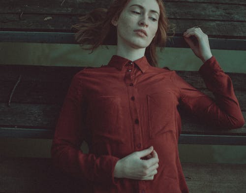 Dreamy woman with red hair lying on timber pier