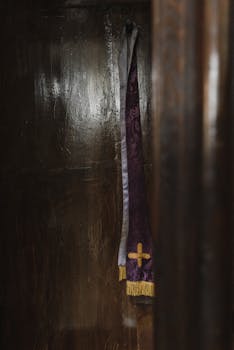 特写：紫色礼拜堂内，黑色木制忏悔室悬挂着十字架