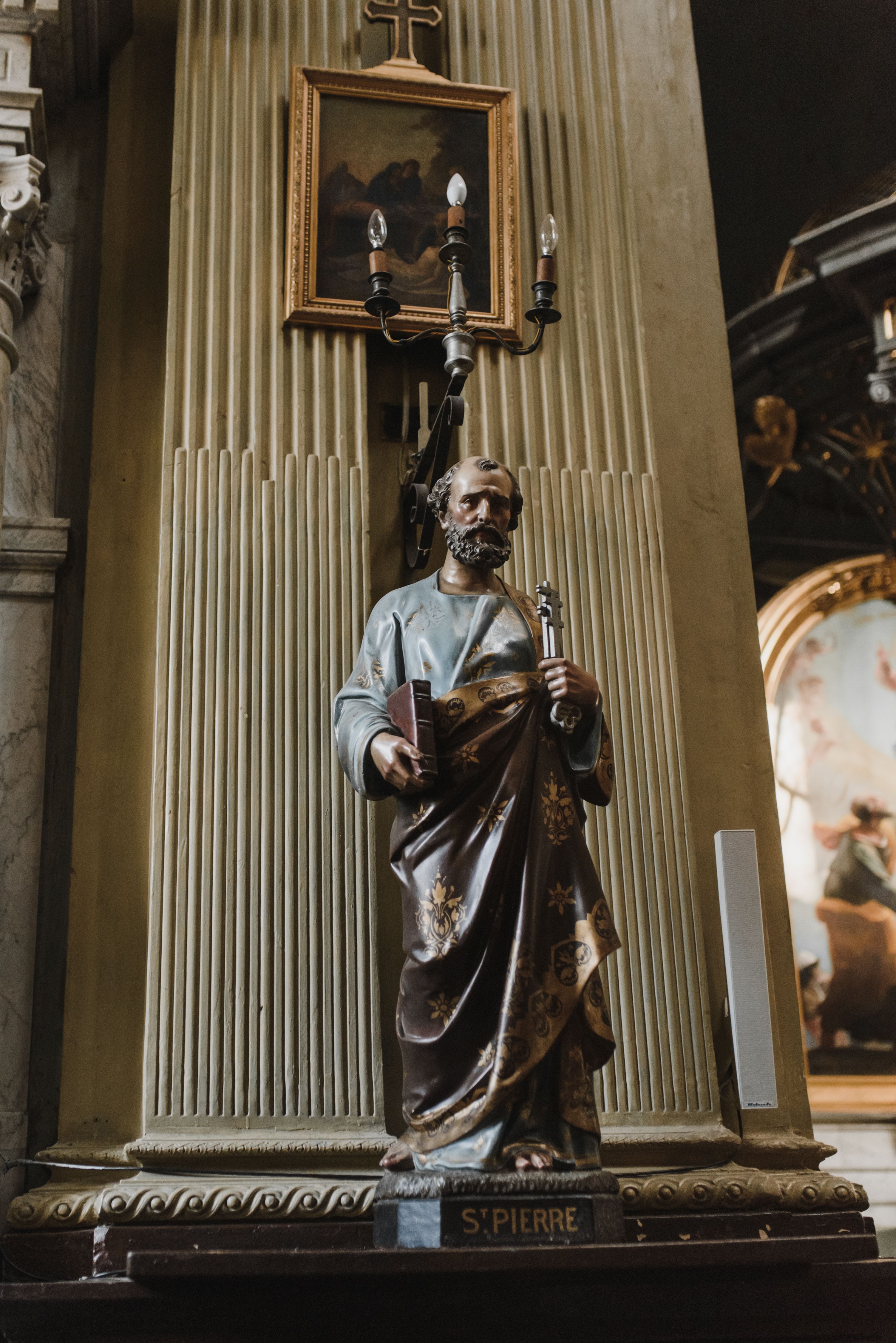 Statue of Saint Pierre inside a historic church, showcasing religious art and architecture.