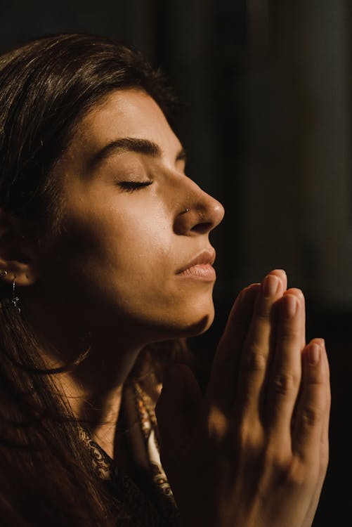 Close-Up Shot of a Woman Praying 